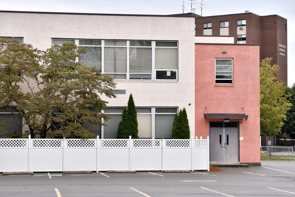 The former Sacred Heart elementary school stands in front of apartment buildings named for Monsignor Anthony DeAngelis in West Warwick, Rhode Island.
