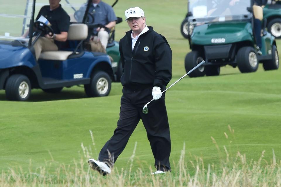 Donald Trump (C) walks as he plays a round of golf on the Ailsa course at Trump Turnberry, the luxury golf resort of US President Donald Trump, in Turnberry, southwest of Glasgow, Scotland on July 14, 2018