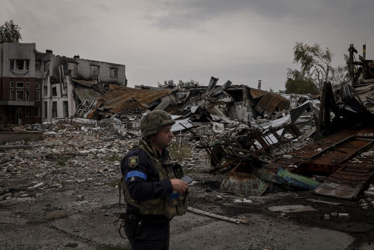 Un oficial ucraniano camina en medio de una fábrica de pan destruida en Lyman
