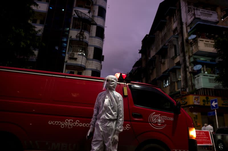 FILE PHOTO: FILE PHOTO: A medical staff wearing a protective suit stands near an ambulance, amid the outbreak of the coronavirus disease (COVID-19), in Yangon