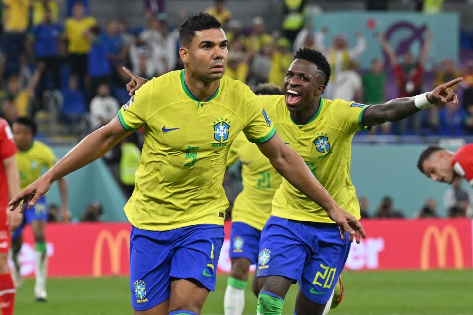 Brazil midfielder Casemiro, left, celebrates with teammate Vinicius Junior after he scored his team's first goal during their World Cup match against Switzerland in Doha on Nov. 28, 2022.