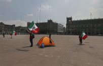 Demonstrators wave Mexican flags during a protest to demand the resignation of Mexican President Andrés Manuel López Obrador, commonly known by his initials AMLO, in Mexico City's main square the Zocalo, Wednesday, Sept. 23, 2020. (AP Photo/Marco Ugarte)