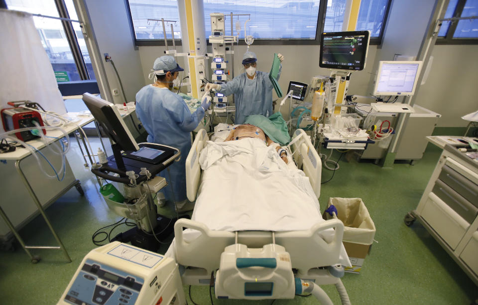 Medical staff members tend to a patient in the COVID-19 Intensive Care Unit of the Papa Giovanni XIII hospital in Bergamo, Italy, Thursday, March 18, 2021. Bergamo’s state-of-the-art Pope John XXIII Hospital verged on collapse last March: as army trucks ferried virus dead from the city’s over-taxed crematoria, doctors struggled to care for 600 COVID patients, 100 in intensive care. One year later, the picture is much improved: the hospital now is treating fewer than 200 virus patients, just one quarter of those requiring intensive care. (AP Photo/Antonio Calanni)