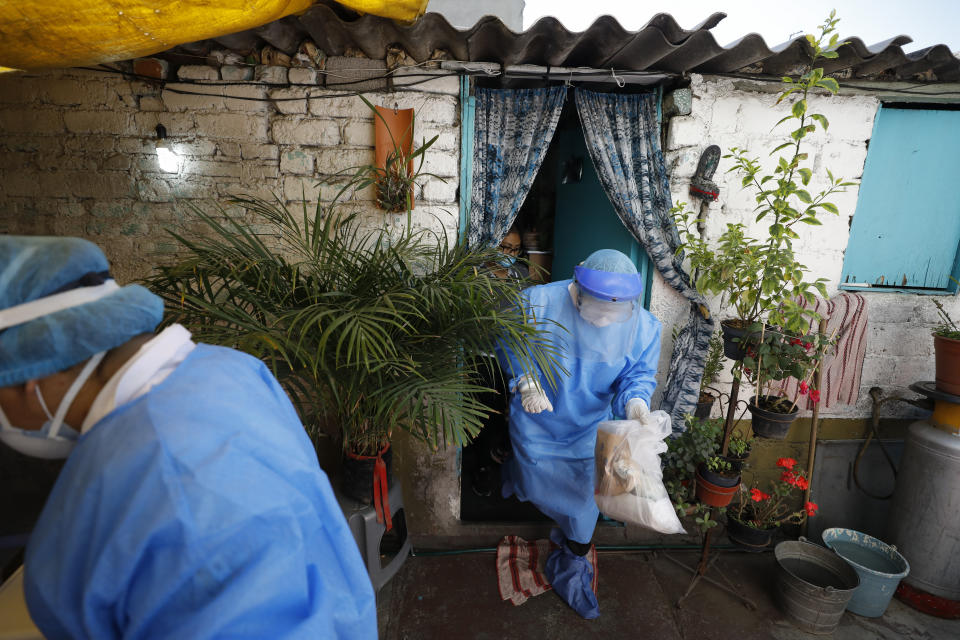 Doctors Delia Caudillo, center, and Monserrat Castaneda, leave after conducting a COVID-19 test for 82-year-old Modesta Caballero Serrano at her home in the Venustiano Carranza borough of Mexico City, Thursday, Nov. 19, 2020. (AP Photo/Rebecca Blackwell)