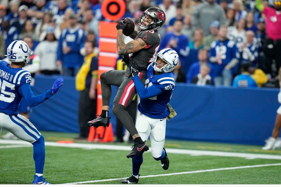 Indianapolis Colts cornerback Jaylon Jones (40) tackles Tampa Bay Buccaneers wide receiver Mike Evans (13) after a catch during the first half of an NFL football game Sunday, Nov. 26, 2023, in Indianapolis. (AP Photo/Darron Cummings)