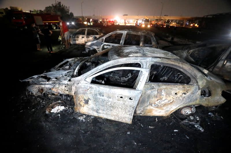 Burned vehicles are seen following a fire that broke out in Egypt's Shuqair-Mostorod crude oil pipeline, at the beginning of Cairo-Ismailia road