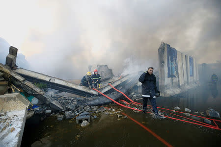 FILE PHOTO: Firefighters inspect after a fire at a storage site in Baghdad, housing the boxes from Iraq's May parliamentary election, Iraq June 10, 2018. REUTERS/Thaier Al-Sudani /File Photo