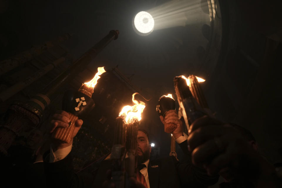 Christian pilgrims hold candles during the Holy Fire ceremony, a day before Easter, at the Church of the Holy Sepulcher, where many Christians believe Jesus was crucified, buried and resurrected, in Jerusalem's Old City, Saturday, April 15, 2023. (AP Photo/Mahmoud Illean)