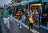 Students wear face masks as they leave a subway in Frankfurt, Germany, Wednesday, Oct. 28, 2020. (AP Photo/Michael Probst)