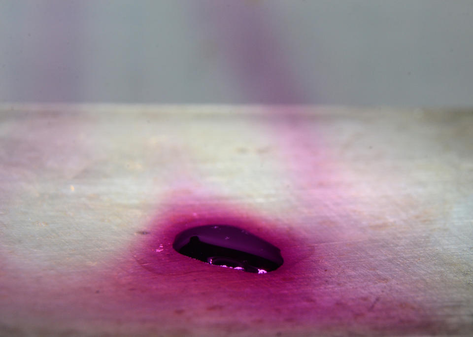 Iodine evaporates, causing violet vapors to rise from the melt.