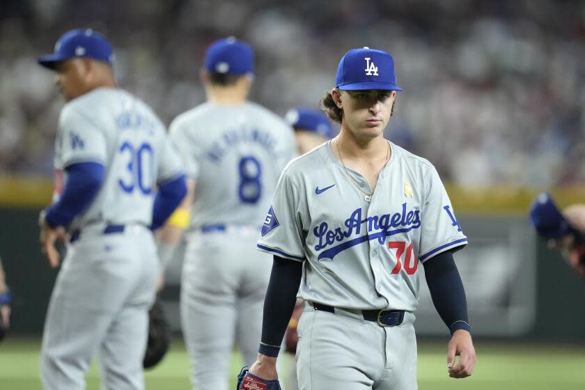 Los Angeles Dodgers starter Justin Wrobleski (70) walks to the dugout as manager Dave Roberts.