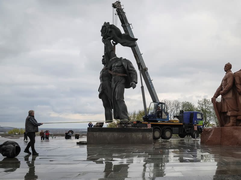 A Soviet monument to a friendship between Ukrainian and Russian nations is seen during its demolition in central Kyiv