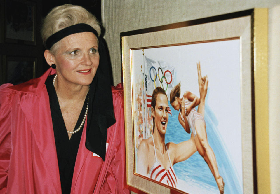 FILE - Pat McCormick stands in front of artwork of herself at the Olympic Hall of Fame in New York, Dec. 13, 1985. McCormick died Tuesday, March 7, 2023, in Santa Ana, Calif., at age 92, according to her son, Tim McCormick. (AP Photo/Dave Pickoff, File)