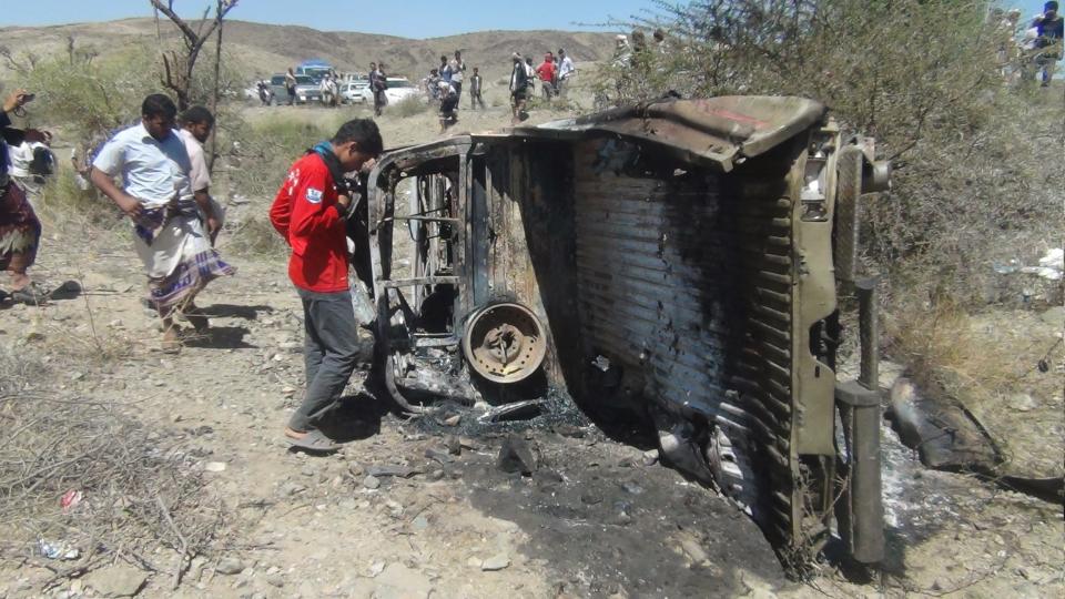 People inspect the wreckage of a car hit by an air strike in the central Yemeni province of al-Bayda April 19, 2014. The air strike killed 13 suspected al Qaeda militants in the central Yemeni province of al-Bayda on Saturday, security and tribal sources said. REUTERS/Stringer (YEMEN - Tags: POLITICS CIVIL UNREST)