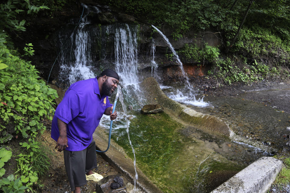 Kenyetta Hunt visits a spring along Route 52 in McDowell County, W.Va., where he and his family have collected water for decades because they don't trust the water provided by local utilities in their homes on June 7, 2022. Hunt said he visits the spring at least once a week to fill five gallon jugs of water to use for drinking and cooking. (AP Photo/Leah Willingham)