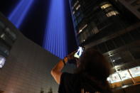 <p>A woman takes a photo of the Tribute in Light with her mobile device on Sept. 11, 2017. (Gordon Donovan/Yahoo News) </p>