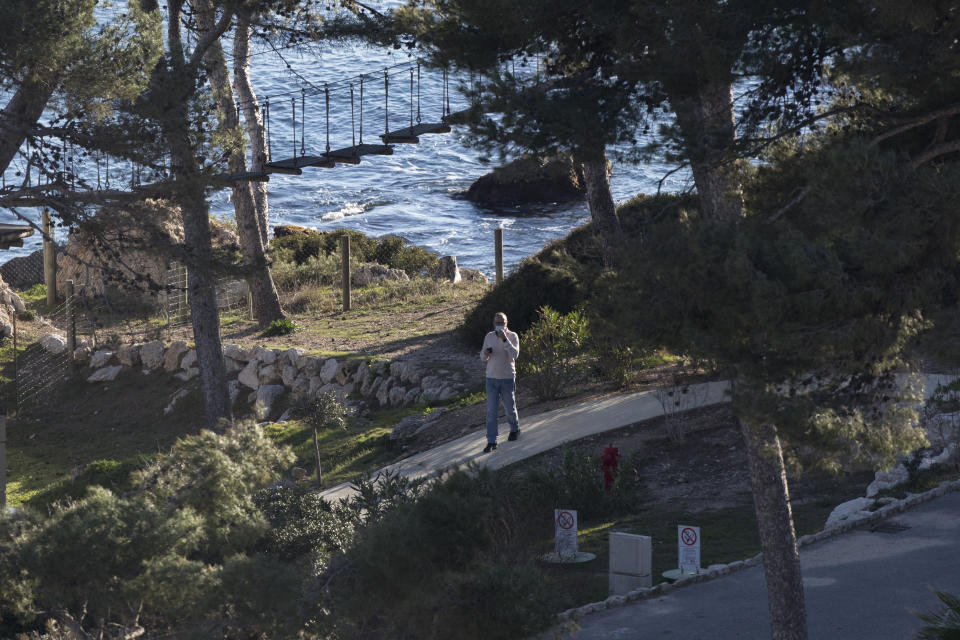 A person wearing a mask is pictured at a complex used as a quarantined vacation center in Carry-le-Rouet, southern France, which is currently accommodating French citizens repatriated from the virus-hit city of Wuhan, Wednesday, Feb. 5, 2020. More than 20,000 people have been infected by the outbreak of a respiratory illness from the coronavirus in China. France has issued an advisory, warning against any non-essential travel to China and suggesting that French citizens who were already there return home. (AP Photo/Daniel Cole)