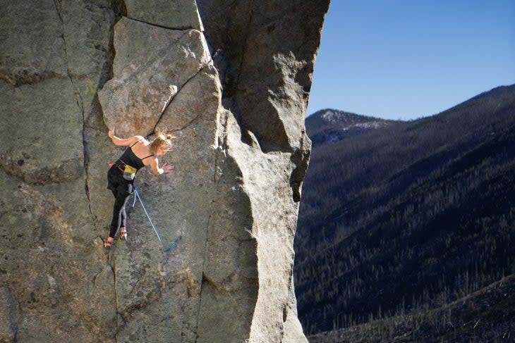 <span class="article__caption">Notice how the climber, located above and to the left of her last clipped draw, has the rope to the right of both legs?</span> If she was going to smear her right foot high, under her hand, she’d want to put her foot under the rope. But if she wanted to put her foot out right, maybe to get a drop knee in that faint seam, she’d want to put it <em>over</em> the rope. (Photo: Kiff Alcocer)