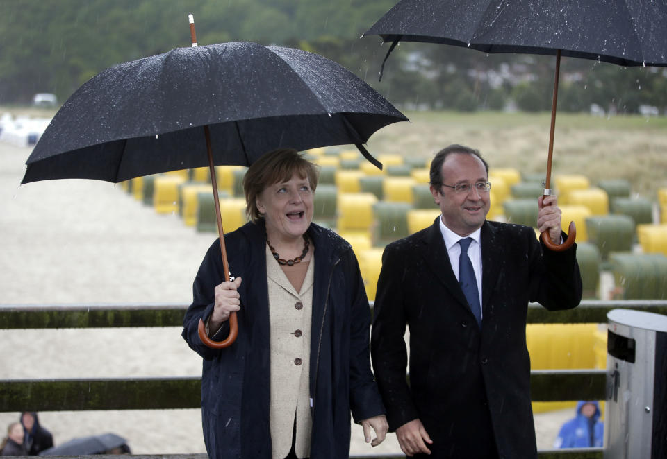 German Chancellor Angela Merkel, left, and the President of France, Francois Hollande, right, pose for the media during a visit to the baltic sea island of Ruegen, northern Germany, Friday, May 9, 2014. Merkel and Hollande meet for two days on the island of Ruegen and in the coastal city of Stralsund. (AP Photo / Michael Sohn)