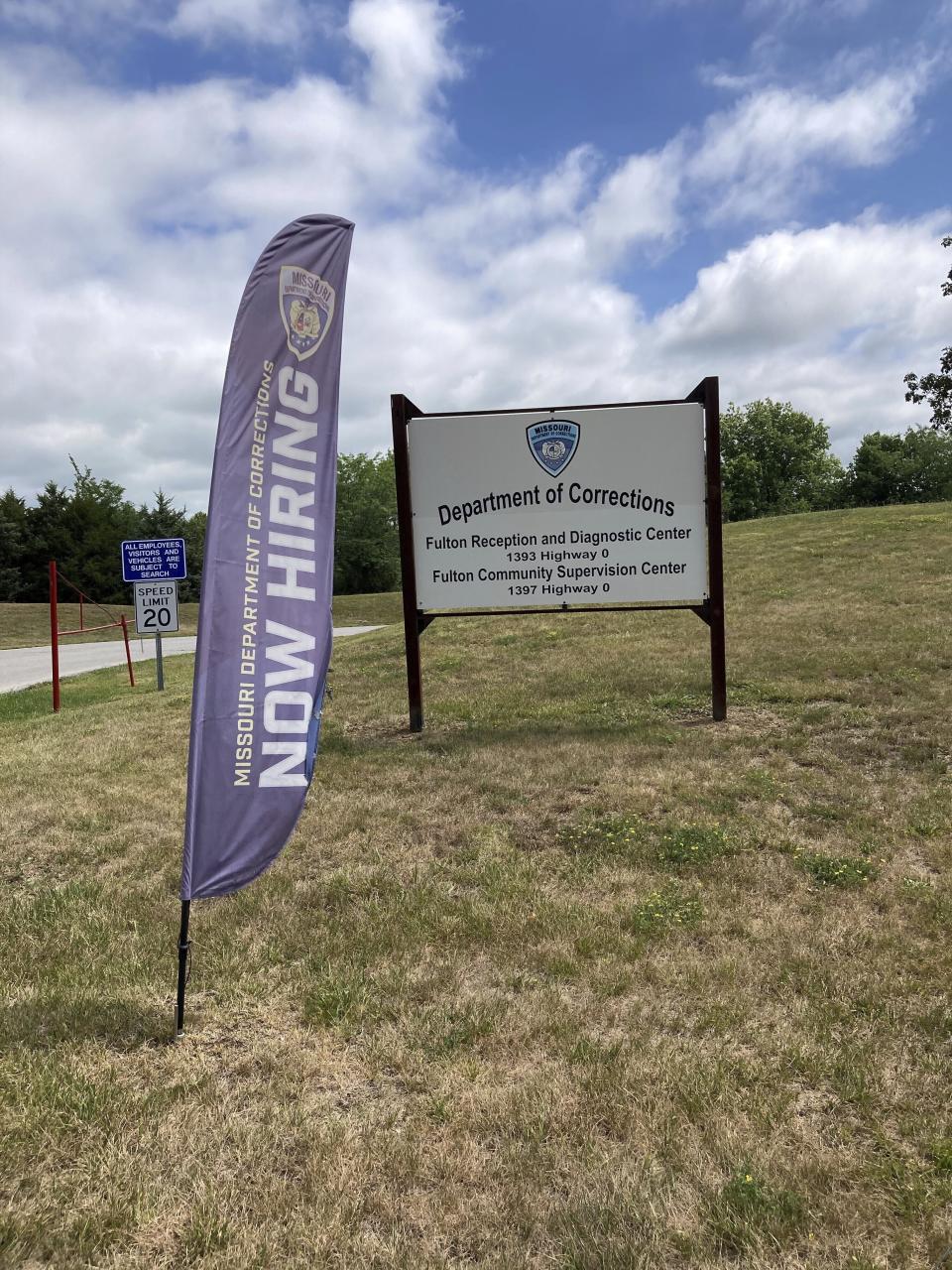 A "Now Hiring" banner waves at the entrance to a Missouri Department of Corrections prison facility in Fulton, Mo., Thursday, July 13, 2023. Nearly 1-in-4 positions were vacant late last year in the Department of Corrections. But vacancies have declined since a pay raise was implemented this spring. (AP Photo/David A. Lieb)