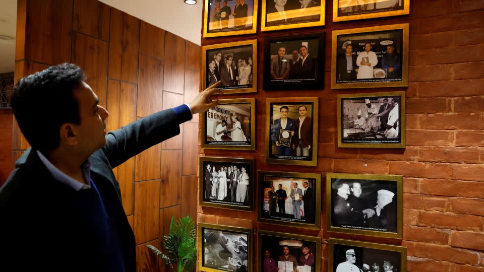 Moti Mahal Delux managing director Monish Gujral shows photographs of celebrities and politicians inside the restaurant in New Delhi on January 23, 2024. - Sahiba Chawdhary/Reuters