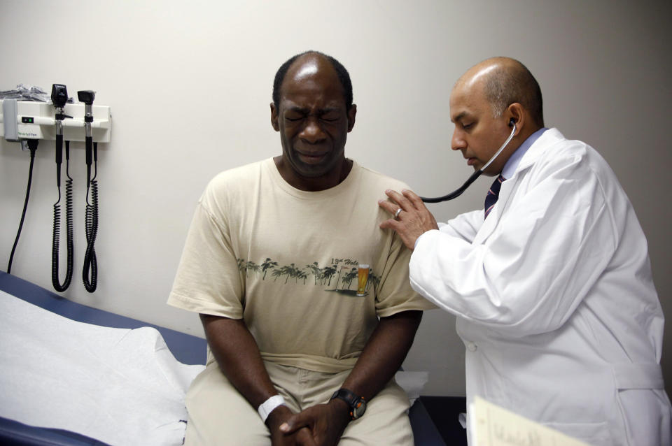 Ernest Sass, 52, (L) winces as he is attended to by Girish Bobby Kapur, M.D. (R) in a room used to see patients who don't require treatment for trauma inside the emergency room at Ben Taub General Hospital in Houston, Texas July 27, 2009.  Houston, the fourth-largest American city, is a case study in the extremes of the U.S. healthcare system.   It boasts the immense medical center that offers top-notch care at its 13 hospitals, but also has a higher ratio of uninsured patients than any major U.S. city: about 30 percent. To match feature USA-HEALTHCARE/TEXAS   REUTERS/Jessica Rinaldi (UNITED STATES SOCIETY HEALTH POLITICS)