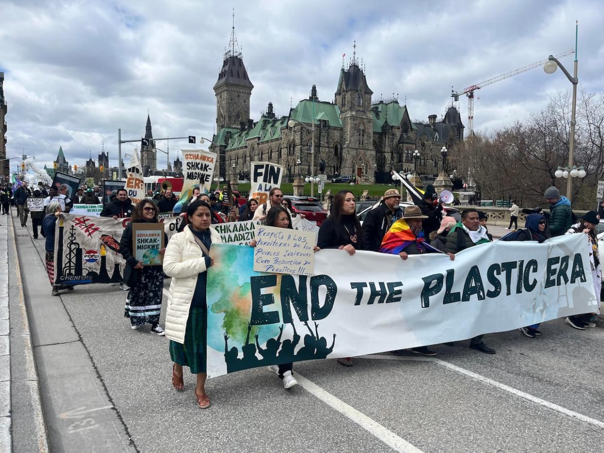 Demonstrators marched Sunday from Parliament Hill down Wellington Street to the Shaw Centre, where talks are set to take place this week on how to address global plastic pollution. (Camille Kasisi-Monet/CBC - image credit)