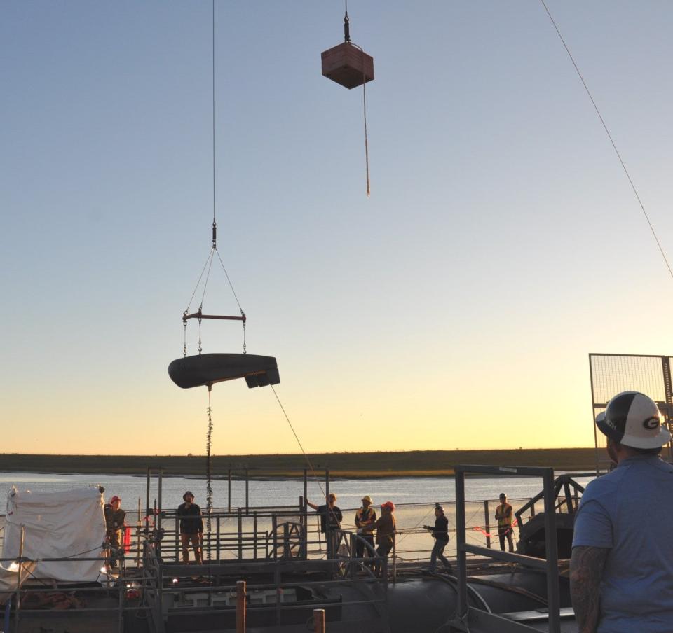 A picture of the recent "buoy fly" at the Trident Refit Facility. The counterweight mentioned in the TRF's Facebook post is visible above to the right of the buoy itself. <em>USN</em>