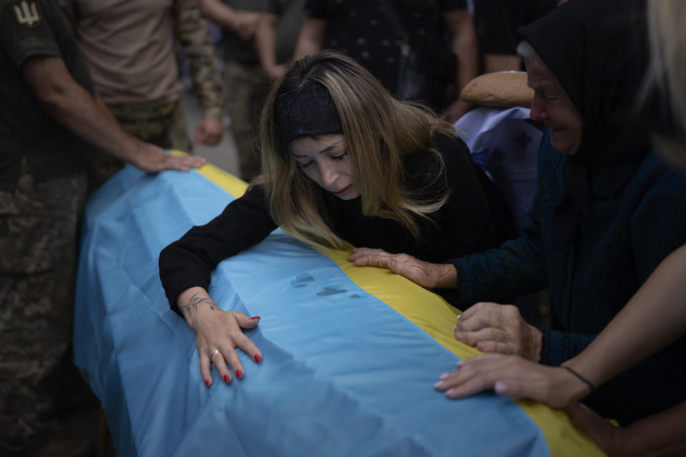 Anastasiia Okhrimenko, 26, cries over a coffin containing the body of her husband Yurii Stiahliuk, a Ukrainian serviceman who died in combat on Aug. 24 in Maryinka, Donetsk, during his funeral in Bucha, Ukraine, Wednesday, Aug. 31, 2022. As the conflict that killed her loved one still rages on Anastasiia wrestles with a question that all of war-torn Ukraine must grapple with: After loss, what comes next? (AP Photo/Emilio Morenatti)