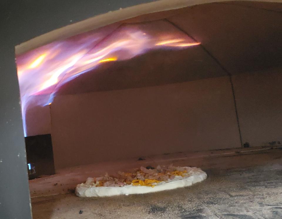 As soon as a pizza in placed inside the new brick pizza oven a Pour Folk Provisions, flames shoot out over the pizza, cooking it in two to three minutes to crispy perfection.