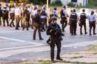 Police line up to block the street as protesters gathered after a shooting incident in St. Louis, Missouri August 19, 2015. REUTERS/Kenny Bahr