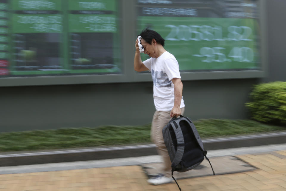 A man walks by an electronic stock board of a securities firm in Tokyo, Wednesday, Aug. 21, 2019. Asia stock markets followed Wall Street lower Wednesday as investors looked ahead to a speech by the Federal Reserve chairman for signs of possible plans for more U.S. interest rate cuts. (AP Photo/Koji Sasahara)