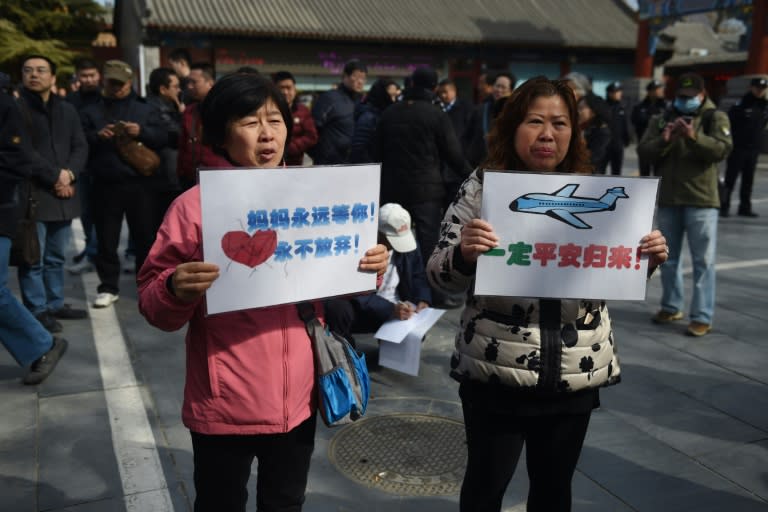 Relatives of passengers missing on Malaysia Airlines MH370 hold placards outside the Lama Temple in Beijing in March