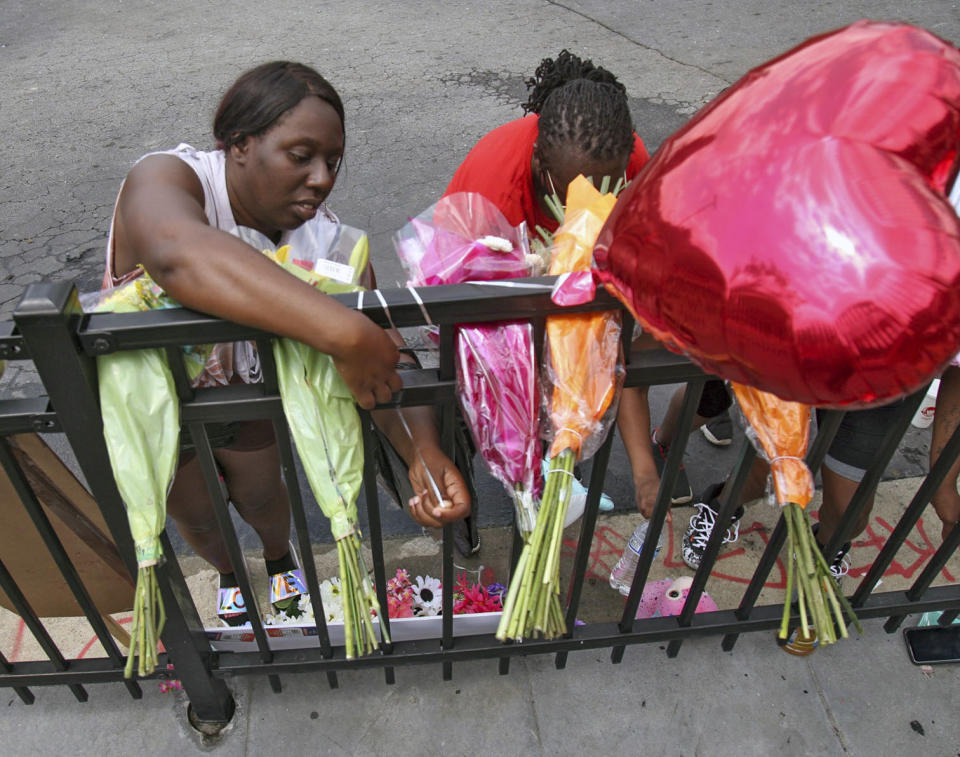 People attend to a memorial at the site of a destroyed Wendy's restaurant Sunday, June 14, 2020, in Atlanta. On Saturday, protestors set fire to the Wendy's where Rayshard Brooks, a black man, was shot and killed by Atlanta police Friday evening following a struggle in the drive-thru line. (Steve Schaefer/Atlanta Journal-Constitution via AP)