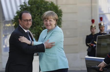 French President Francois Hollande (L) welcomes German Chancellor Angela Merkel before talks and a dinner at the Elysee Palace in Paris, France, July 6, 2015. REUTERS/Philippe Wojazer