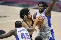 Cleveland Cavaliers' Jarrett Allen, center, drives to the basket against Detroit Pistons' Isaiah Stewart and Detroit Pistons' Sekou Doumbouya, left, in the first half of an NBA basketball game, Wednesday, Jan. 27, 2021, in Cleveland. (AP Photo/Tony Dejak)