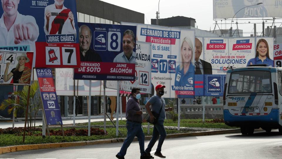 Wahlplakate der Kandidaten stehen an einer Straße in Lima.