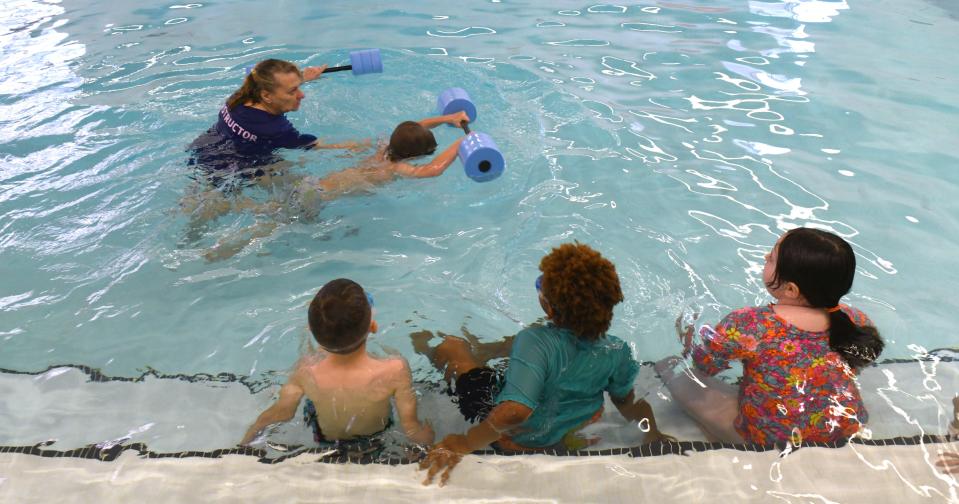 Ben Mitchell gets help from instructor Glenda Lehmiller as first grade students from Frazer Elementary School take swim lessons at the Eric Snow Family YMCA in Canton as part of a partnership between the YMCA and Plain Local Schools.