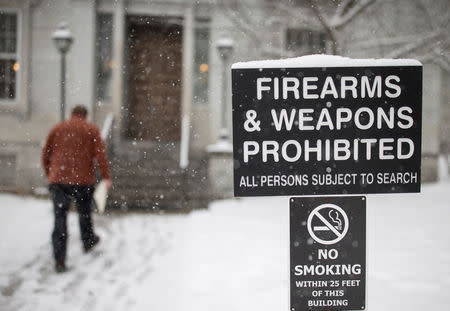 FILE PHOTO: A man walks past a sign prohibiting firearms and weapons inside the State Legislature in Montpelier, Vermont, U.S., March 13, 2018. REUTERS/Christinne Muschi/File Photo