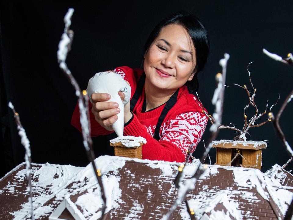 Cake designer Michelle Wibowo works on her gingerbread version of the McCallister house