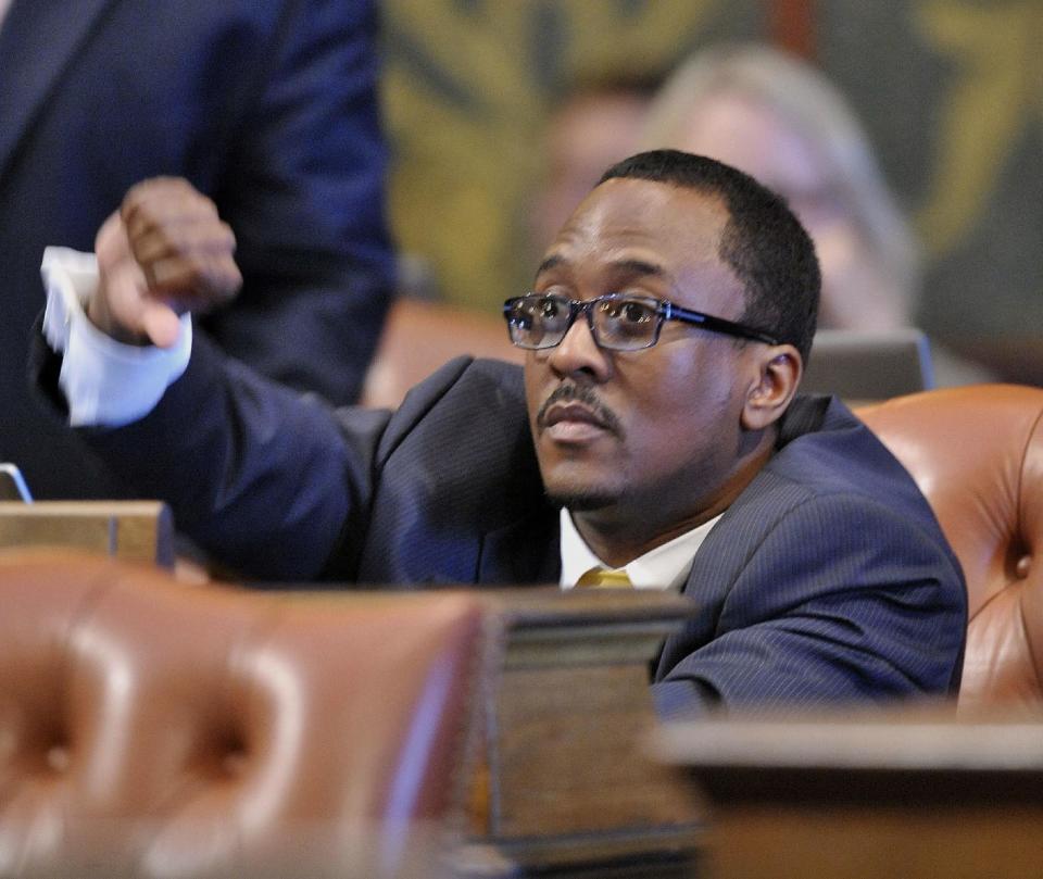 In this May 21, 2013, photo, Michigan Rep. Brian Banks sits at his desk on the floor of the House of Representatives at the Capitol in Lansing, Mich. Banks, a Michigan lawmaker with a lengthy criminal record, resigned from office Monday, Feb. 6, 2017, as part of a plea deal to resolve charges that he submitted fraudulent pay stubs to secure a $3,000 loan in 2010. (Dale G. Young/Detroit News via AP)