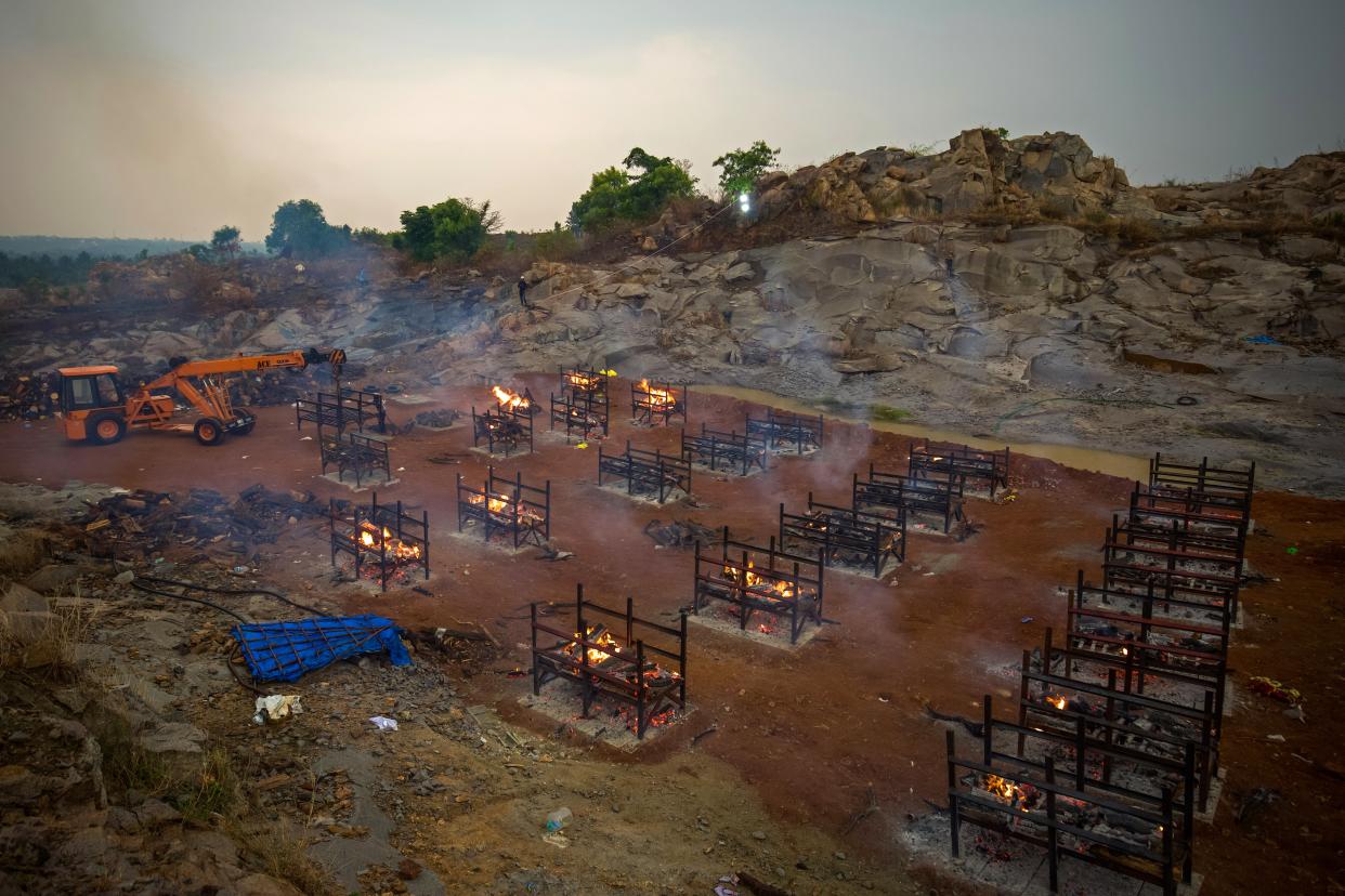 <p> A crane places new biers in a disused granite quarry repurposed to cremate the dead due to Covid-19 on April 30, 2021 in Bengaluru, India</p> (Getty Images)