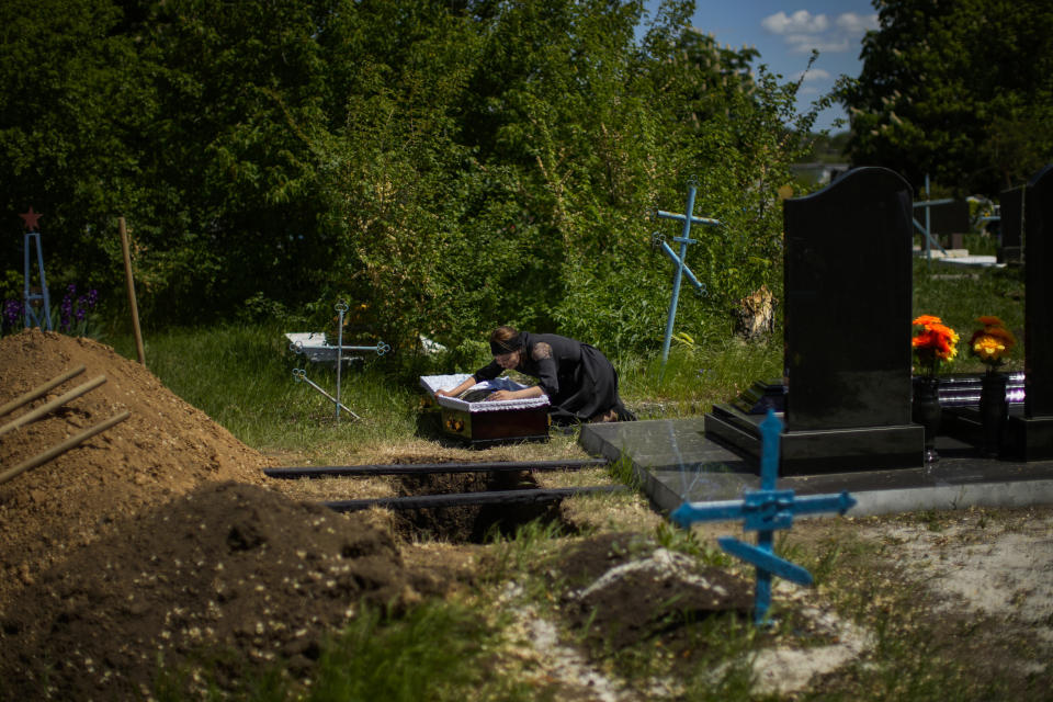 Iuliia Loseva llora sobre el ataúd de su marido Volodymyr Losev, de 38 años, durante su funeral el lunes 16 de mayo de 2022 en un cementerio en Zorya Truda, región de Odesa, Ucrania. Volodymyr Losev, un soldado voluntario ucraniano, murió el 7 de mayo cuando el vehículo militar que conducía pasó encima de una mina en el este de Ucrania. (AP Foto/Francisco Seco)