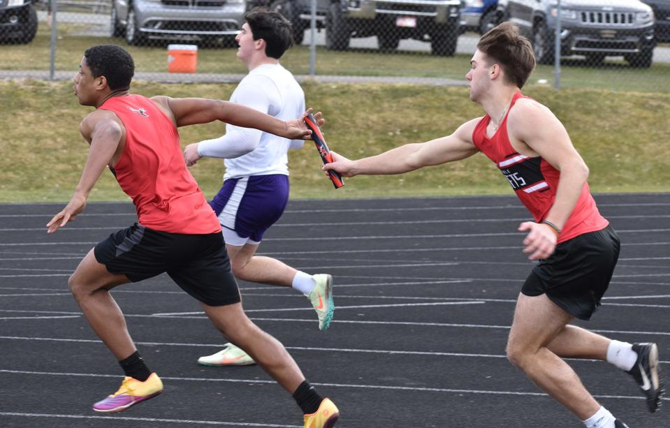 Honesdale's Conlan Keast and Alex Loftin exchange the baton during Tuesday's 400M relay versus Scranton Prep.