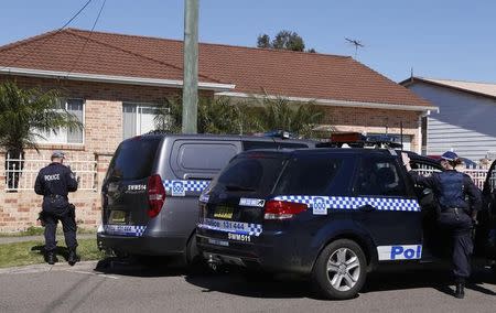Police stand outside a house that was involved in pre-dawn raids in the western Sydney suburb of Guilford September 18, 2014. REUTERS/David Gray