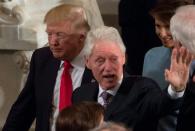 US President Donald Trump passes former president Bill Clinton while leaving the Inaugural Luncheon in Washington, DC