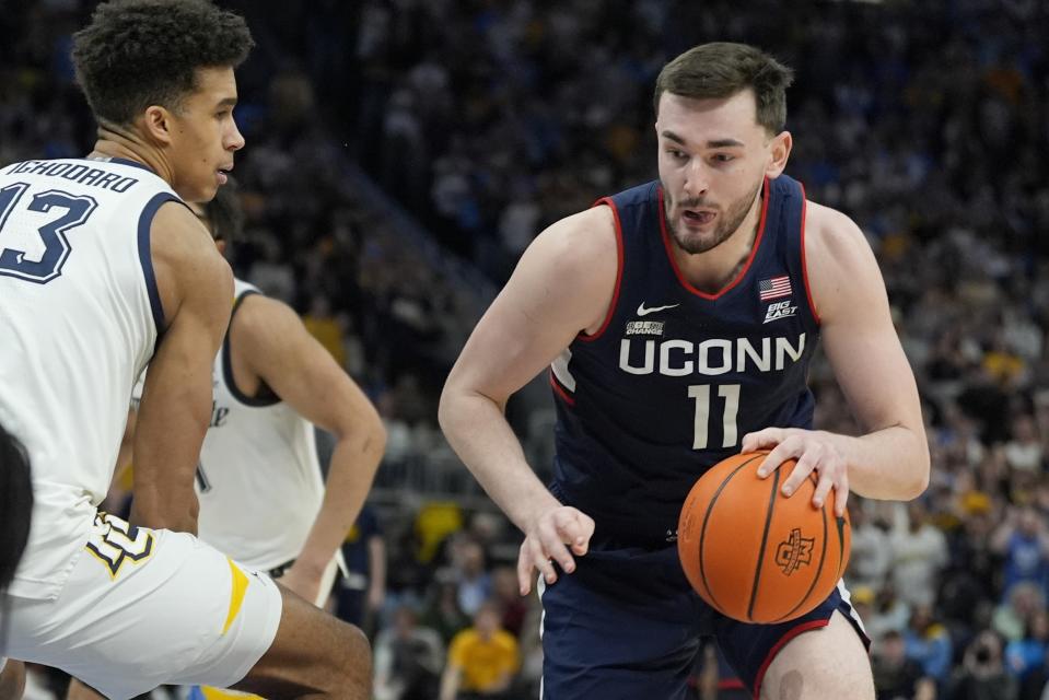 UConn's Alex Karaban drives past Marquette's Oso Ighodaro during the second half of an NCAA college basketball game Wednesday, March 6, 2024, in Milwaukee. UConn won 74-67. (AP Photo/Morry Gash)