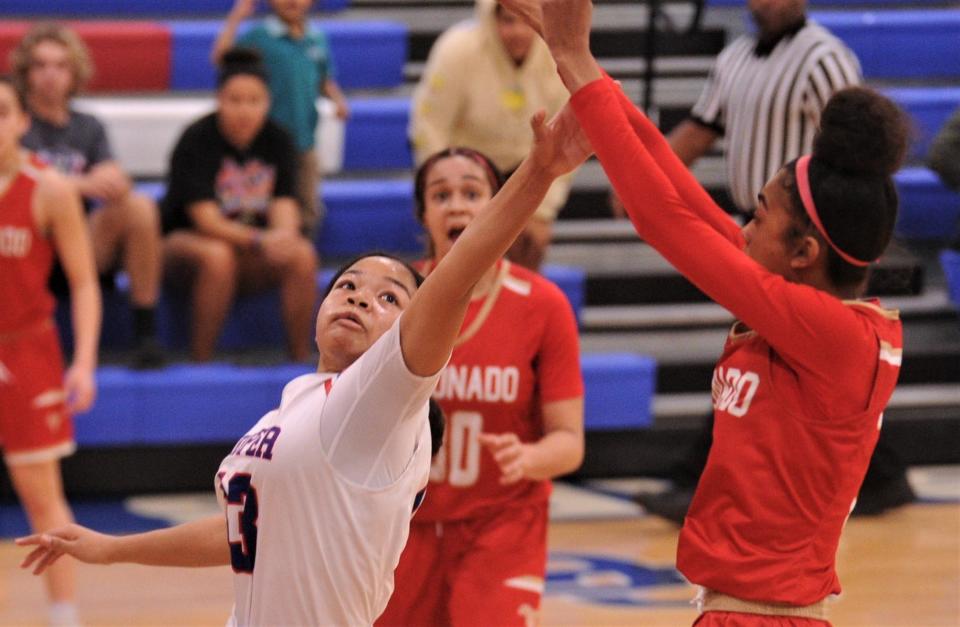 Cooper's Kyla Speights, left, defends as Lubbock Coronado's Jannaeleigh Cooper shoots a 3-point goal in the third quarter.