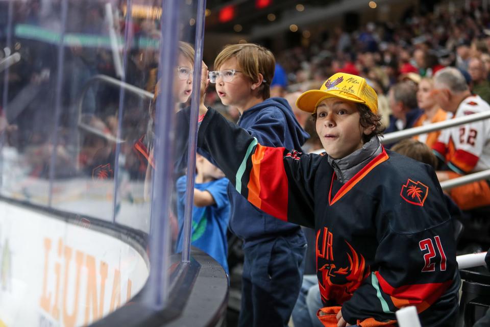 A couple of young Firebirds fans watch their team against the San Jose Barracuda at Acrisure Arena in Palm Desert, Calif., Feb. 28, 2024.