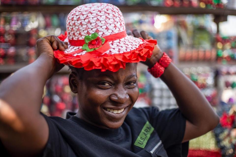 A sales woman tries on a Christmas hat in a market in Ibadan, Nigeria, 18 December 2023. Over 80 million Nigerians are Christians out of a population of 225 million.